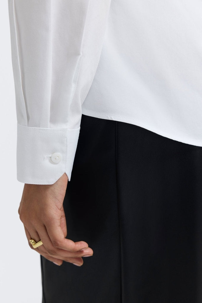 Zoomed in view of the sleeve and buttoned cuff of the Dianna No Iron Pinpoint Long Sleeve Shirt #color_white