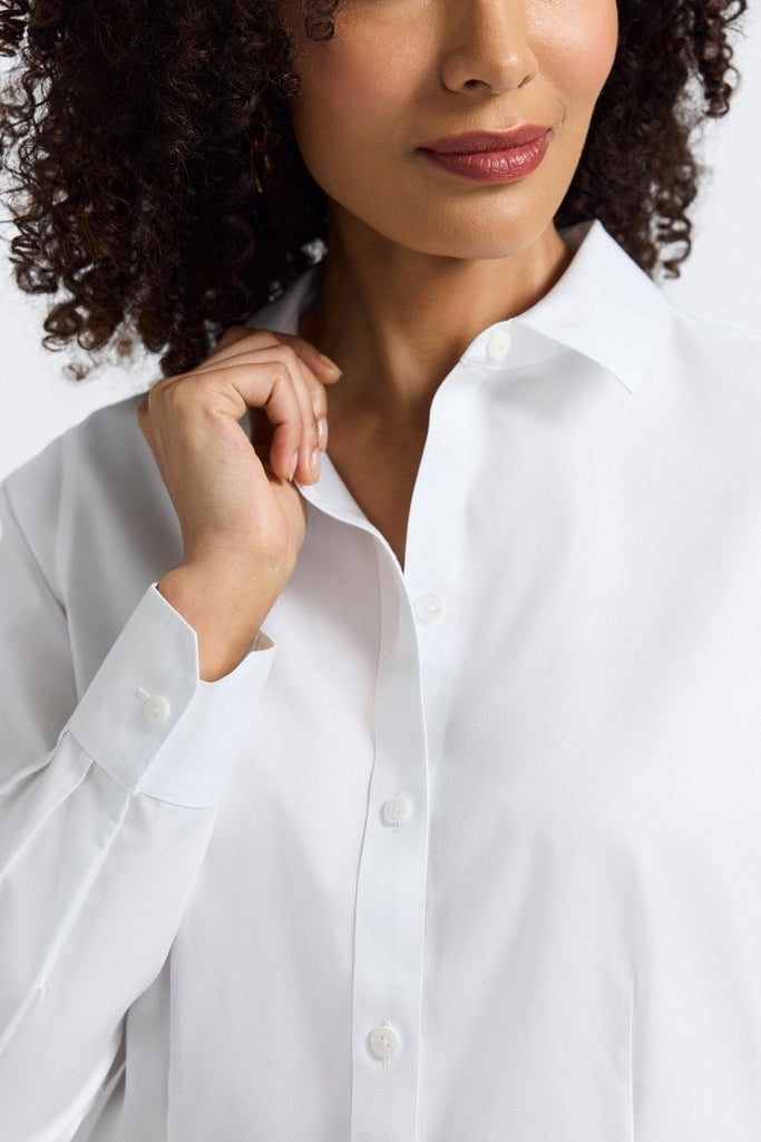 Zoomed in view of the collar and neckline of the Dianna No Iron Pinpoint Long Sleeve Shirt being worn by a woman with her hand on the collar showing off the buttoned cuff #color_white