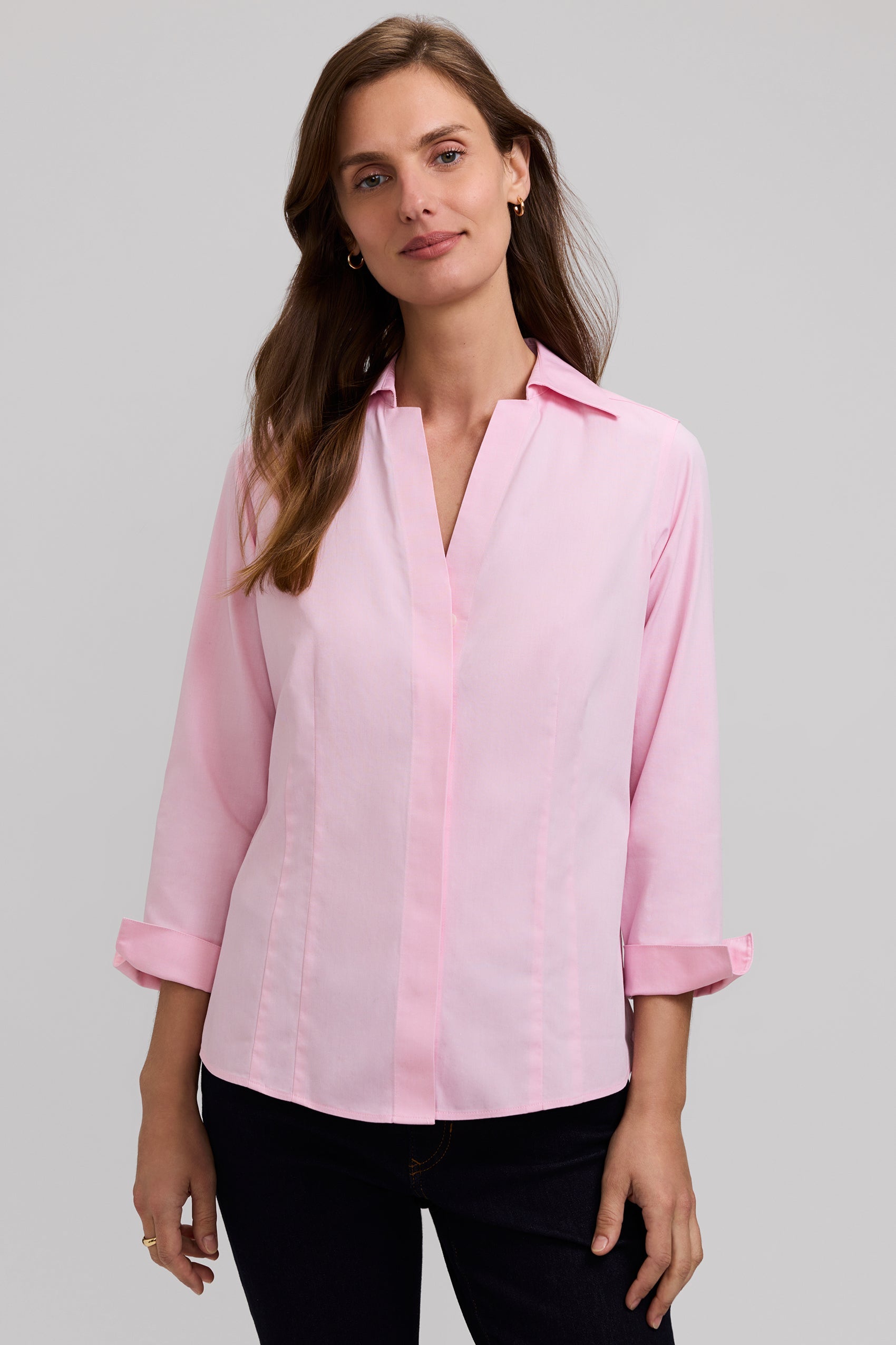 Woman wearing a light pink blouse against a gray background