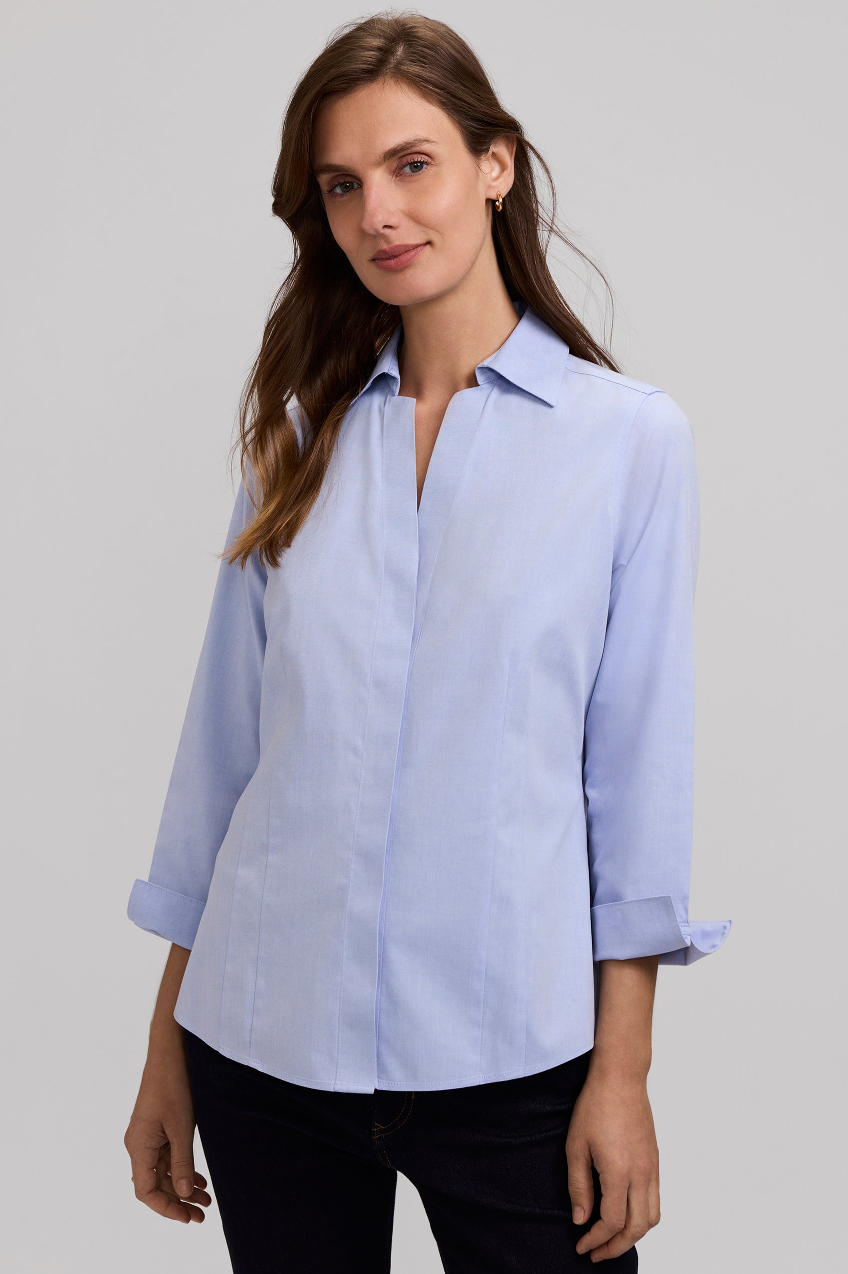 Woman wearing a light blue shirt against a gray background