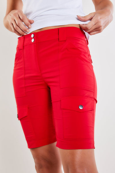 The Best Travel Shorts. Woman Showing the Front Profile of an Apiedi Shorts in Atomic Red.