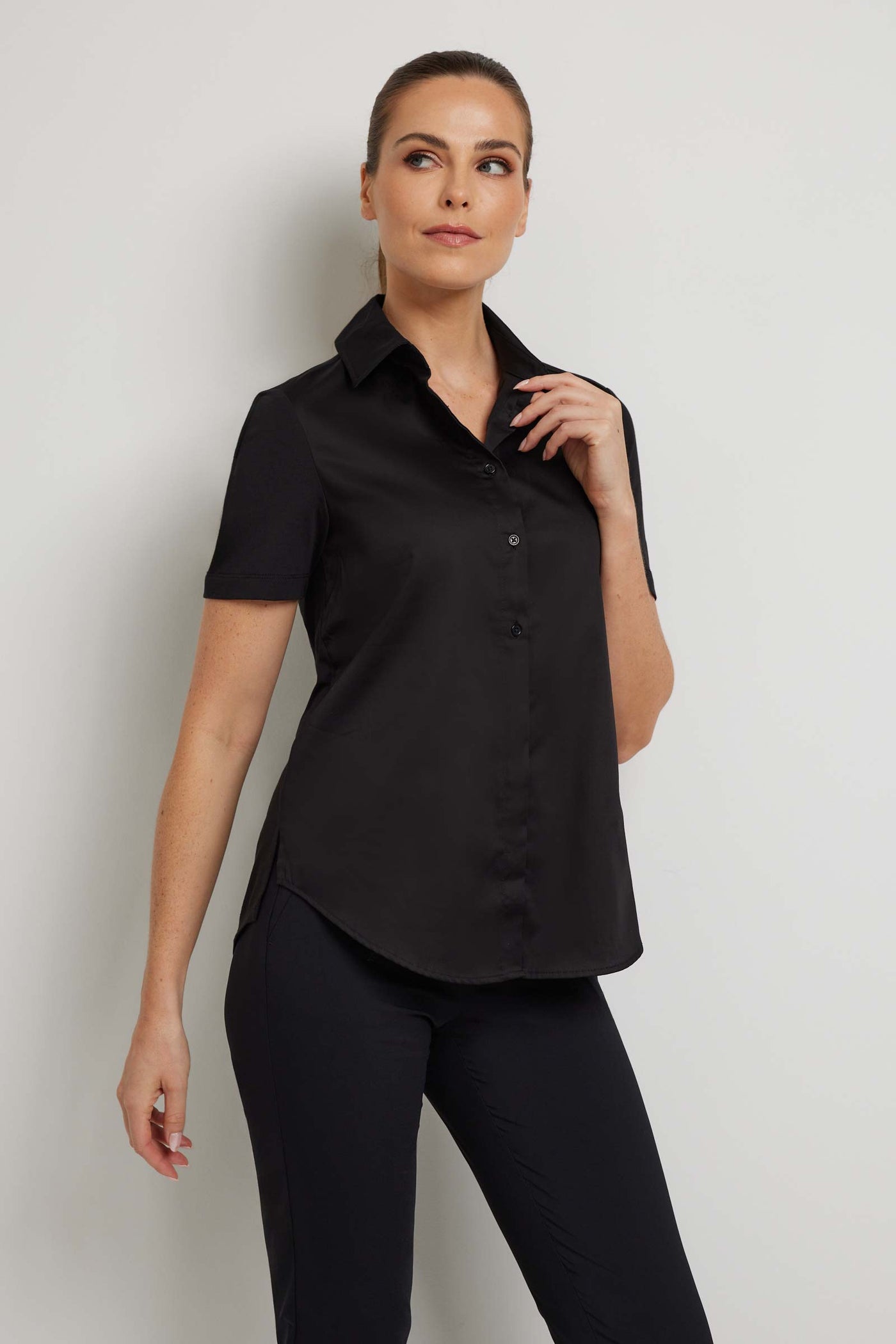 The Best Travel Top. Woman Showing the Front Profile of a Helia Top in Black.