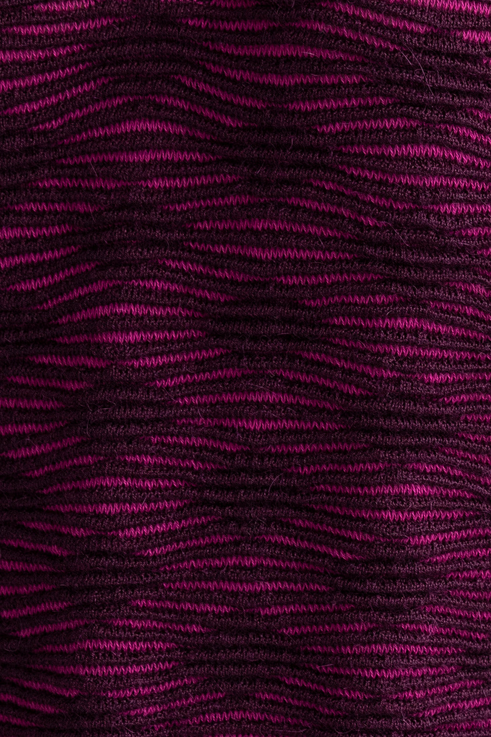Detail shot of the Amelie Polo showcasing the monochromatic textured pattern in fuchsia and aubergine. Ethically made from baby alpaca and cotton.