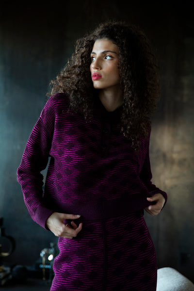Model looking into the distance, wearing a long sleeve polo sweater ethically made from baby alpaca and cotton.