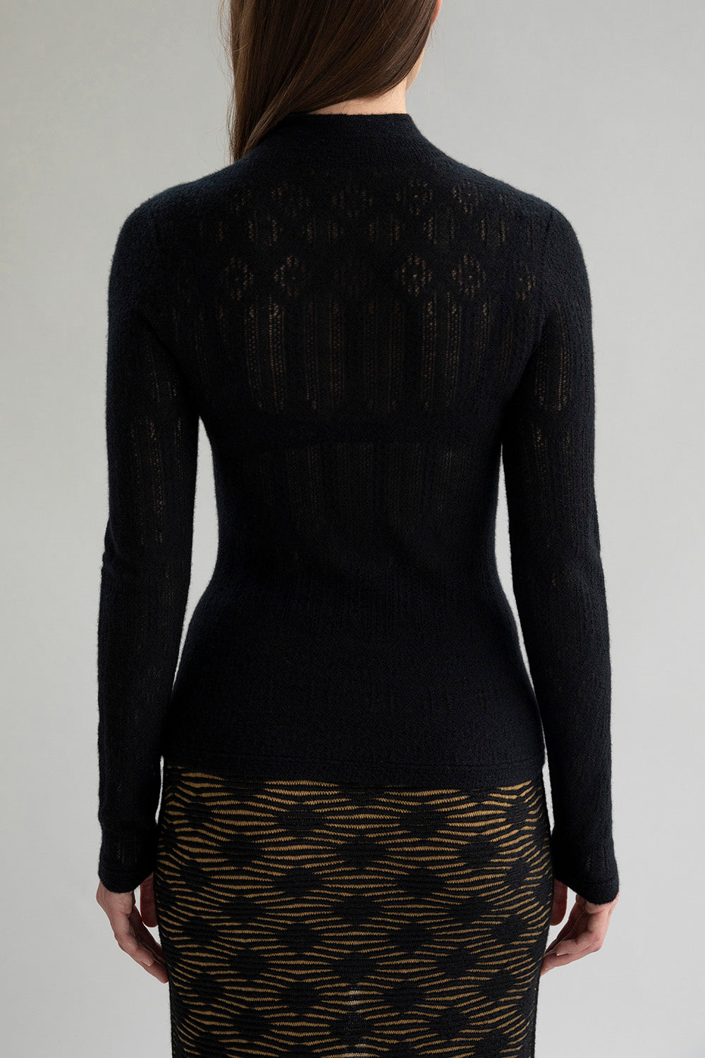 Full back view of a model wearing a black lace pointelle lightweight pullover sweater.