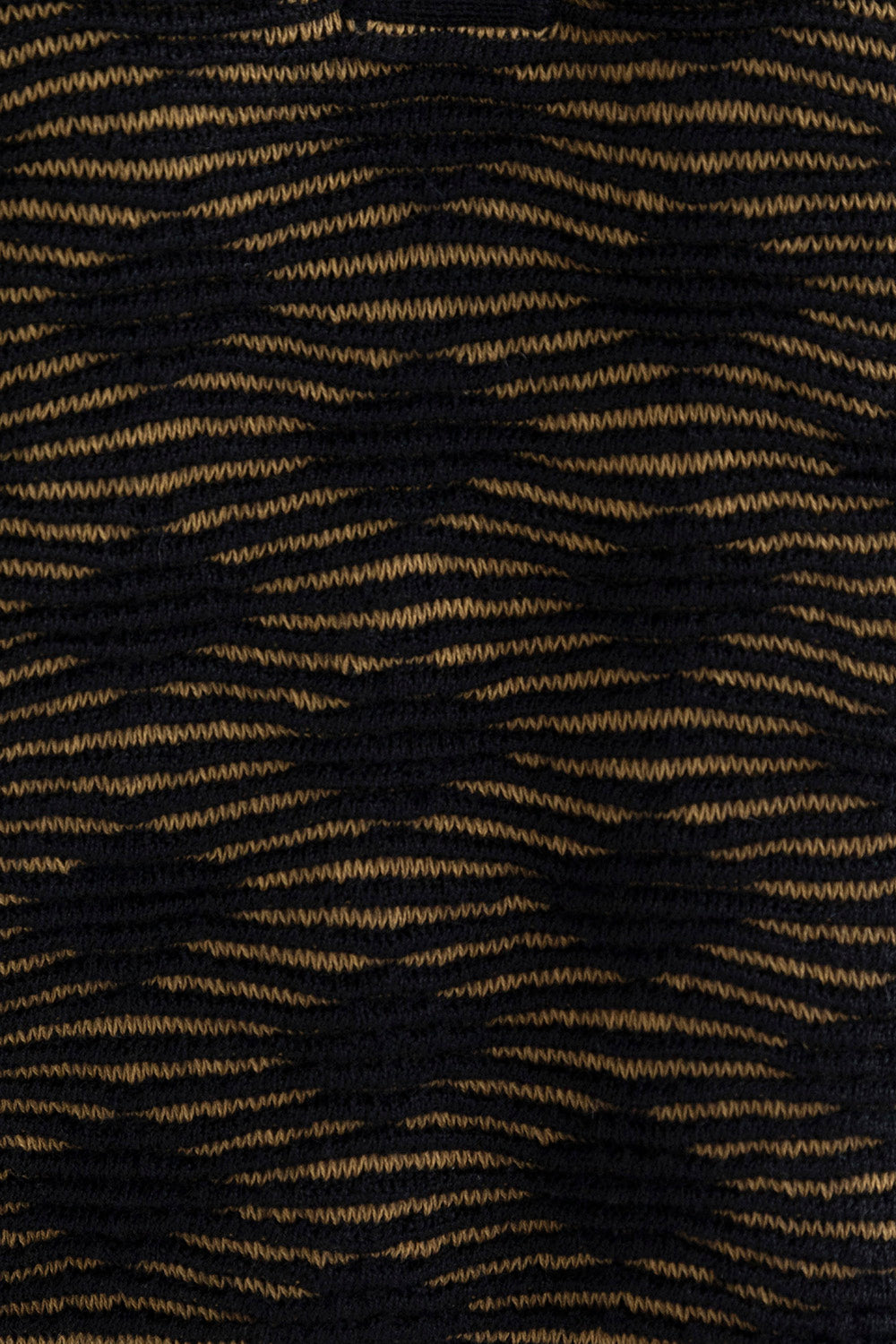 Close-up of the golden black Ines pencil skirt, highlighting the textured pattern in golden and black. Ethically made from baby alpaca and cotton.