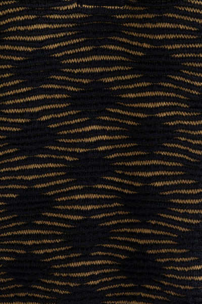 Close-up of the golden black Ines pencil skirt, highlighting the textured pattern in golden and black. Ethically made from baby alpaca and cotton.