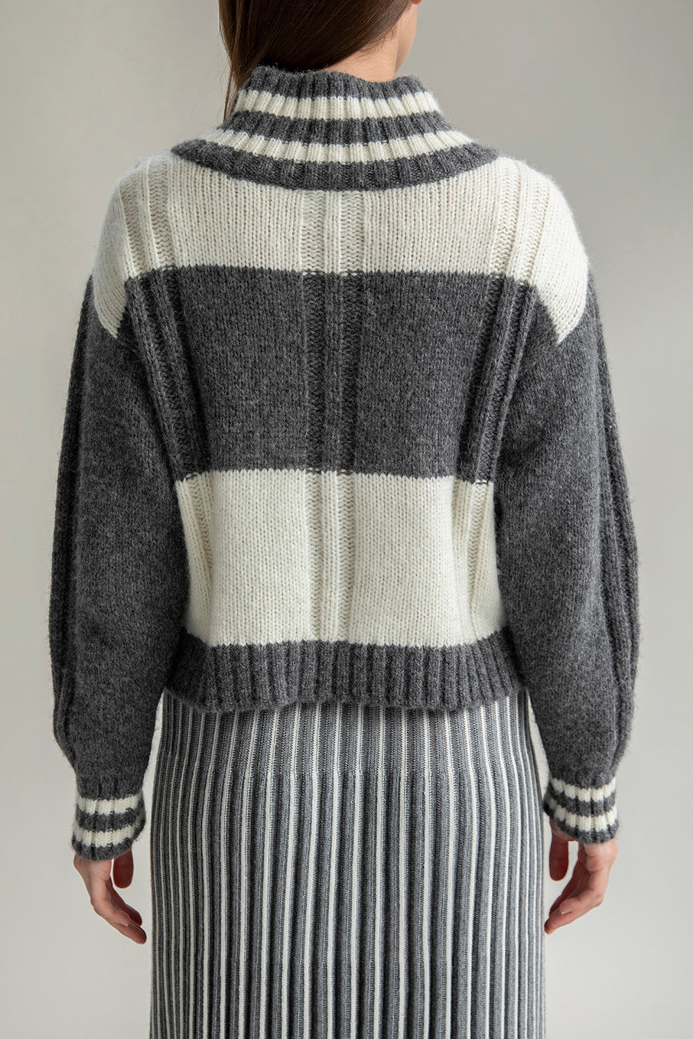 Back view of the Kari V-neck pullover, highlighting its unique checkered pattern and comfortable fit. Perfect for pairing with the Adeline skirt.