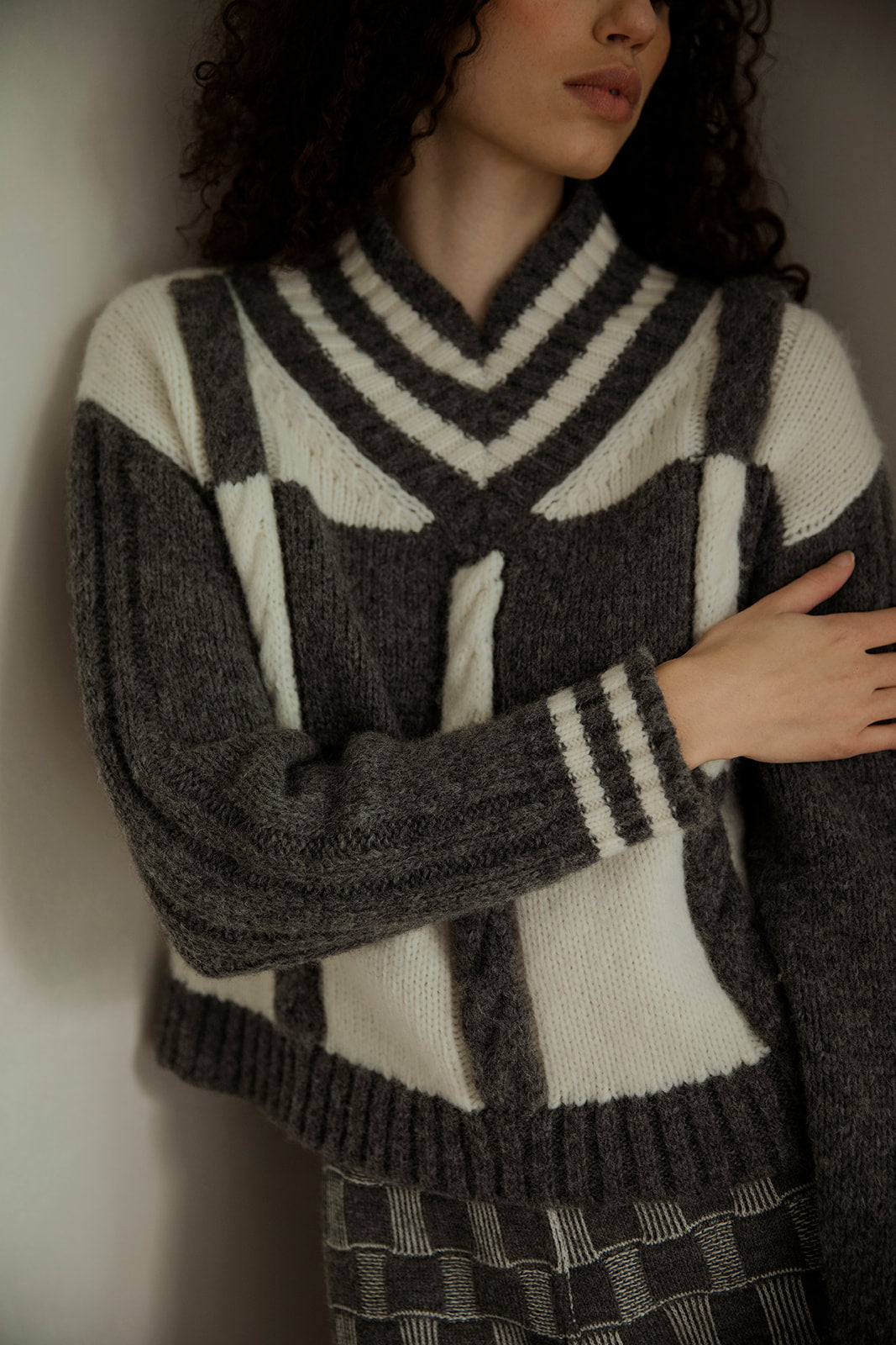 Close-up of the Kari Plaid V Neck Pullover in grey and ivory made from 89% Superfine Alpaca and 11% Nylon.