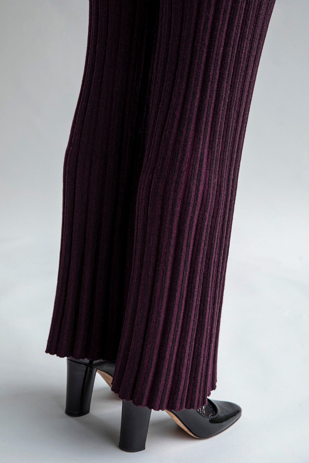 Side view of the pant leg displaying the flare-leg detail and pleated hem effect.