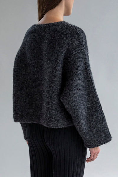 Side view of the Momo Handknit Cardigan in Charcoal, showcasing its relaxed, cropped fit and the soft, textured stitch of the alpaca blend yarn.
