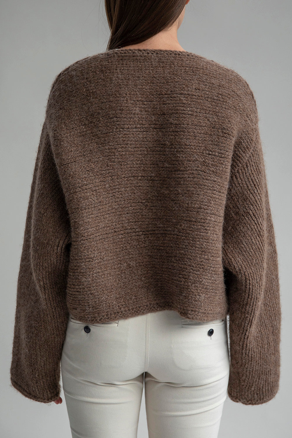 Back view of the Momo Handknit Cardigan in Saddle, highlighting its relaxed, cropped shape and beautiful heavyweight fabric ethically sourced in Peru.