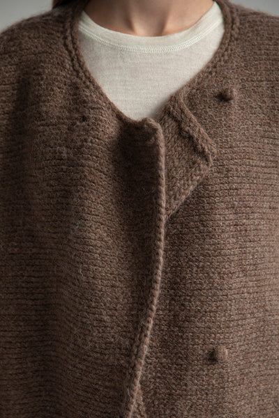Close-up of the front of the Momo Handknit Cardigan in Saddle, showing the hand-crocheted buttons made from matching yarn. Made from 70% Baby Alpaca 23% Nylon and 7% Merino Wool.
