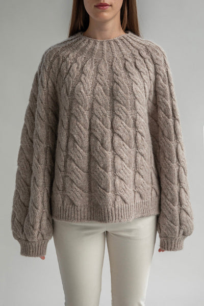 The Tomo Mix Cable Handknit in Oat Heather. The textured pullover is sustainably made by Peruvian artisans from Art Atlas Foundation. Sweater is crafted from 70% baby alpaca 23% nylon and 7% merino wool.
