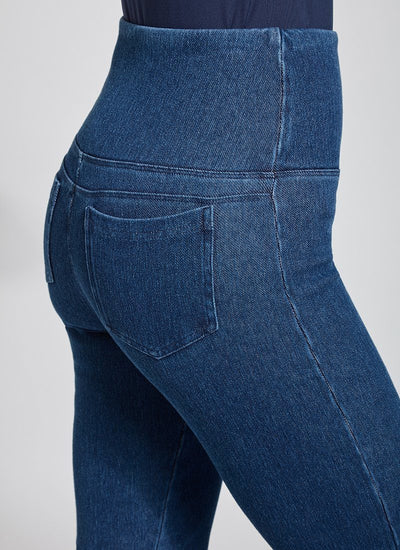 color=Mid Wash, Detailed angled back view of mid wash blue denim straight leg jean leggings with patented concealing waistband